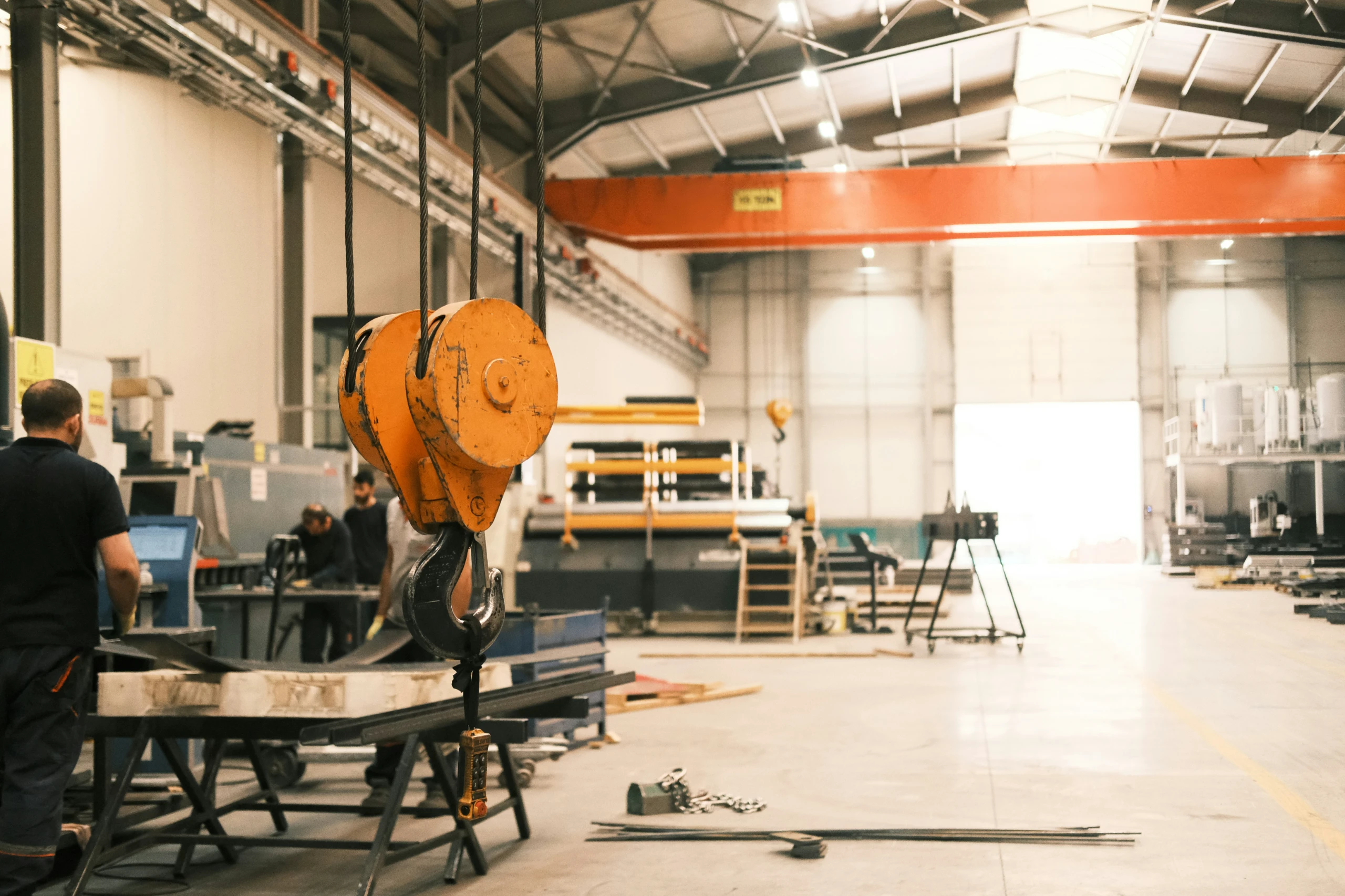 manufacturing plant with overhead crane and metal fabrication workers