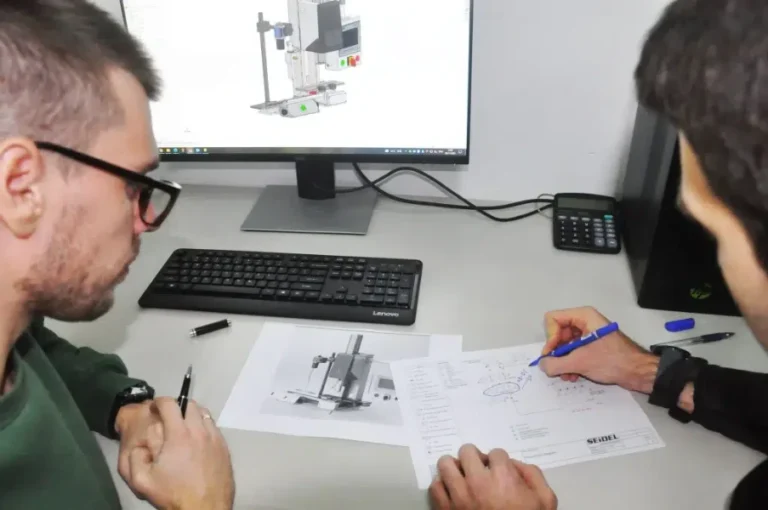 seidel industrial engineers reviewing mechanical equipment blueprints at workstation